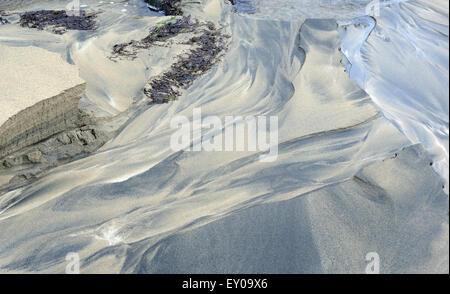 Acqua fresca che scorre attraverso la spiaggia di sabbia della baia del villaggio con la bassa marea realizzazione di tracciati nella sabbia. Hirta, St Kilda, Scotland, Regno Unito. Foto Stock