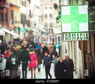 Farmacia segno appeso sulla costruzione in strada affollata Foto Stock