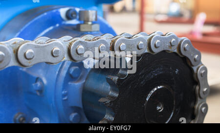 Close-up di catena e pignone. Molto leggera profondità di campo con un paio di maglie della catena nel fuoco. Foto Stock