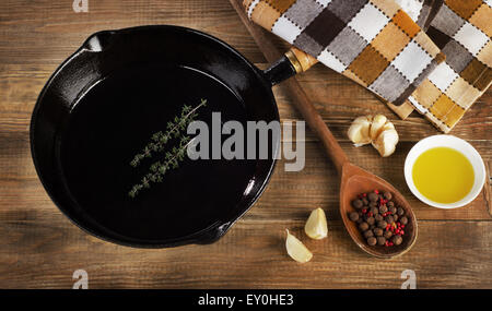 Padella in ghisa su un rustico sfondo di legno. Vista superiore Foto Stock