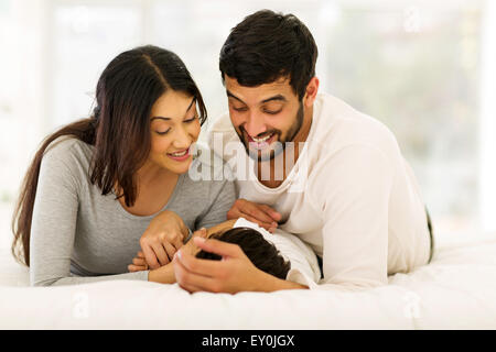 Allegro famiglia indiana giacente sul letto insieme Foto Stock