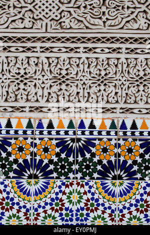 Arabesque stucco parete scolpita dettaglio con piastrelle in ceramica, a Marrakech, Marocco Foto Stock