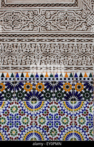 Arabesque stucco parete scolpita dettaglio con piastrelle in ceramica, a Marrakech, Marocco Foto Stock