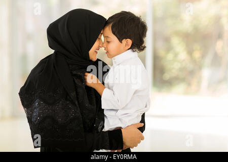 Adorabili metà donna orientale giocando con suo figlio a casa Foto Stock