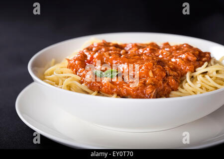 Spaghetti con sugo di tonno su sfondo nero Foto Stock