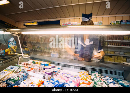 GOMEL, Bielorussia - Giugno 10, 2014: una donna non identificato in un negozio di alimentari nel dipartimento di prodotti lattiero-caseari presso un negozio locale Foto Stock