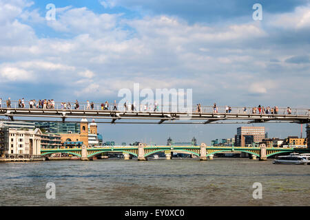 Londra Millennium Footbridge, soprannominata anche "ponte traballante' e irriconoscibile la gente camminare sopra il fiume Tamigi. Di seguito lontano Foto Stock
