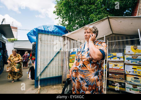 GOMEL, Bielorussia - Giugno 10, 2014: una donna non identificato parlando al telefono al mercato locale Foto Stock