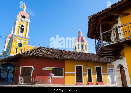 Donna locale con il suo bambino a camminare per le strade di Granada città vecchia, Nicaragua Foto Stock