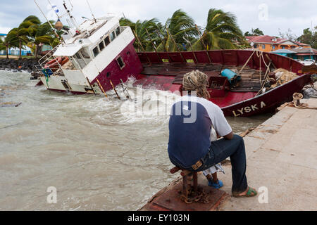 Padre e figlio guardando i danni causati dal passaggio dell uragano Ida in Big Corn Island dock, Nicaragua Foto Stock