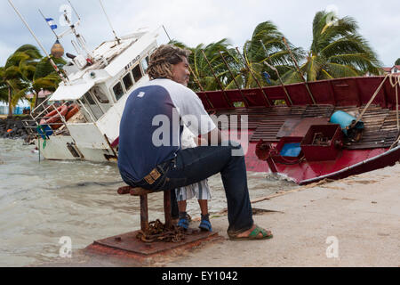 Padre e figlio guardando i danni causati dal passaggio dell uragano Ida in Big Corn Island dock, Nicaragua Foto Stock