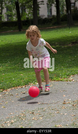 Bambino che gioca con una palla in un parco di New York STATI UNITI D'AMERICA Foto Stock