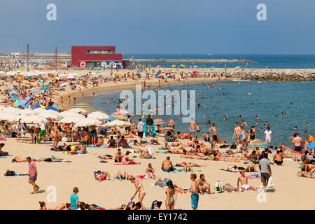 I turisti a prendere il sole sulla Platja Nova Icaria ( Nova Icaria Beach ), Port Olimpic Barcelona Spagna Europa Foto Stock