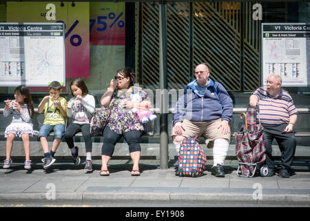 Persone in attesa al riparo di Bus Foto Stock