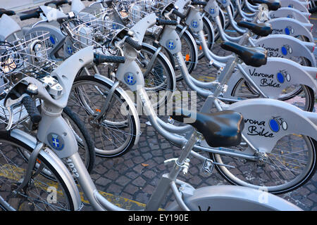 Una fila o biciclette a noleggio in un Verona Stazione bike, Italia Foto Stock