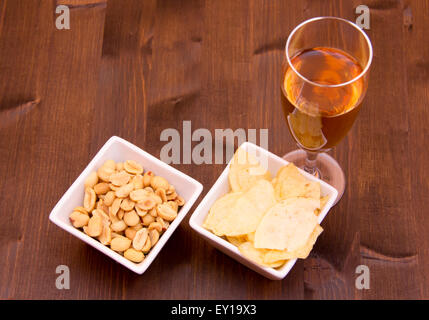 Aperitivo e salatini in ciotole sul tavolo in legno visto da sopra Foto Stock