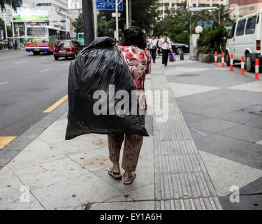 Senior tira un sacchetto di plastica sulla schiena per le strade di Shenzhen Foto Stock