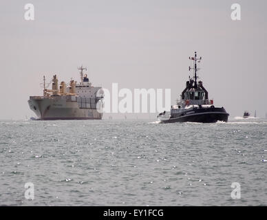 Il rimorchiatore SD abbondante vele a incontrare MV Crown zaffiro nel Solent, Inghilterra Foto Stock