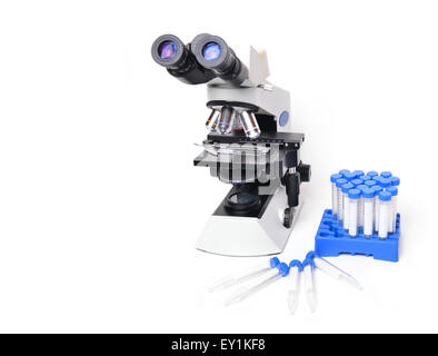 Microscopio con attrezzature di laboratorio su sfondo bianco Foto Stock