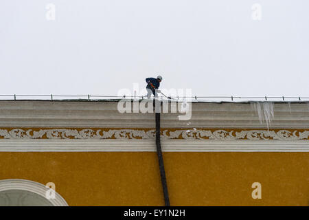 Mosca, Russia, 4 febbraio 2013. Tempesta di neve pesante. Lavoratore rimuove la neve dal tetto dell'edificio arsenale del Cremlino di Mosca Foto Stock