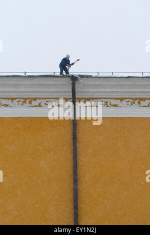 Mosca, Russia, 4 febbraio 2013. Tempesta di neve pesante. Lavoratore rimuove la neve dal tetto dell'edificio arsenale del Cremlino di Mosca Foto Stock