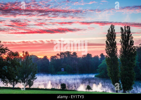 Alba sopra il tempio dorico e il lago nella motivazione della struttura Bowood Station Wagon nel Wiltshire. Foto Stock