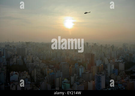 Elicottero al di sopra di un paesaggio urbano con grattacieli al tramonto, São Paulo, Brasile Foto Stock