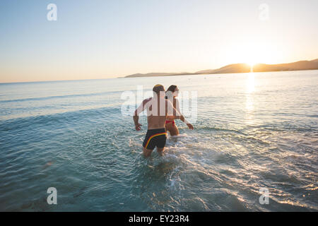 Coppia di giovani bel giovane uomo e donna prendendo un bagno divertendosi in mare Foto Stock