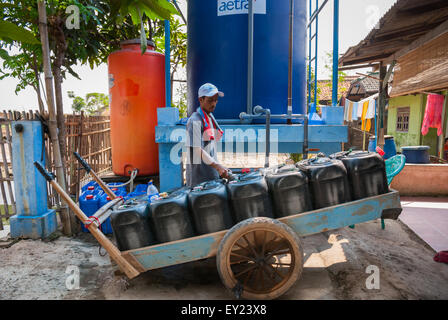 Un venditore di acqua mobile sta riempiendo le sue lattine di jerry ad una stazione di riempimento di acqua a Rorotan, Cilincing, Jakarta del nord, Jakarta, Indonesia. Foto Stock