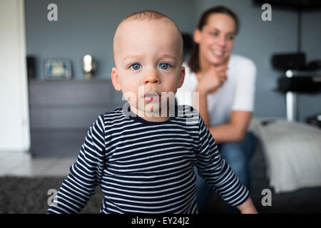 Ritratto di bambino di fronte alla madre in salotto Foto Stock