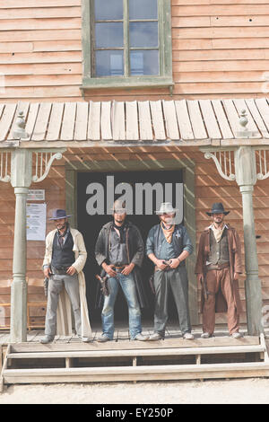 Ritratto di quattro cowboy in piedi sul portico sul selvaggio west set cinematografico, Fort Bravo, Tabernas, Almeria, Spagna Foto Stock