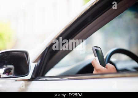 La mano di imprenditore utilizza lo smartphone al finestrino Foto Stock