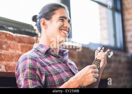 Giovane uomo giocando ukulele Foto Stock