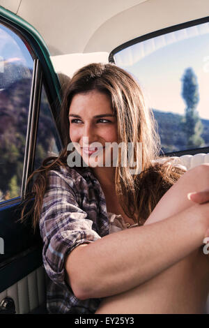 Ritratto di giovane donna nel sedile posteriore della macchina Foto Stock