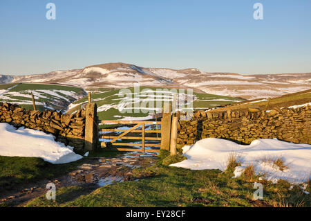 Gateway a un drammatico Peak District paesaggio con resti di tardo inverno neve bagnata in sera la luce del sole. Foto Stock