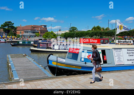 La donna a piedi passato narrowboat regali in barca marina sul fiume Avon, Stratford upon Avon, Warwickshire, Inghilterra, Regno Unito Foto Stock