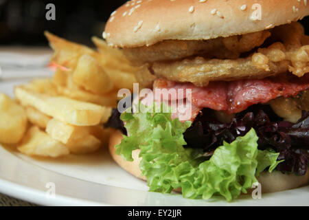 La pancetta formaggio hamburger con patatine. Foto Stock
