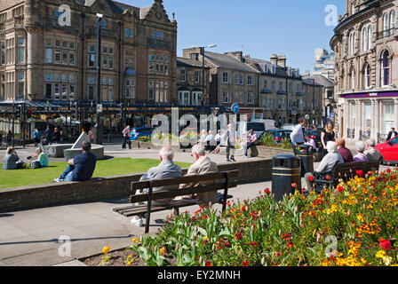 La gente che gode del sole primaverile sedette fuori nel centro della città Harrogate North Yorkshire Inghilterra Regno Unito GB Gran Bretagna Foto Stock