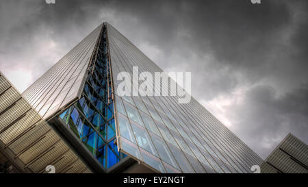 L'iconico Shard a Londra visto dalla base per la ricerca di un lato del moderno edificio di vetro su un nuvoloso Nuvoloso Giorno Foto Stock