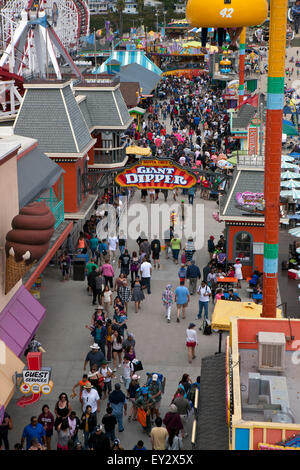 Una folla di gente che passeggia sotto il gigante del bilanciere linea ride, Santa Cruz Boardwalk, Santa Cruz, in California, Stati Uniti d'America Foto Stock