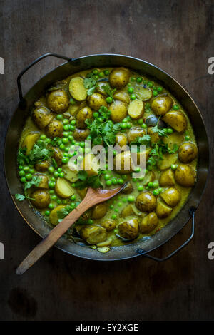 Il segnale di PEA & potatoe curry in una casseruola di ferro sul tavolo di legno. Vista superiore Foto Stock