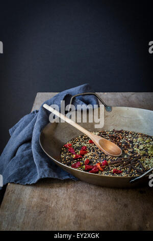 Le spezie intere preparato per la tostatura in padella sul tavolo di legno Foto Stock