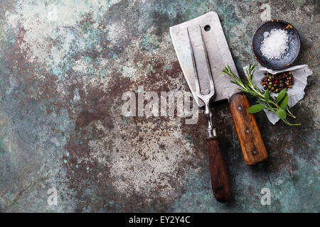 Vintage forcella di carne e Cleaver con condimenti su sfondo di metallo Foto Stock