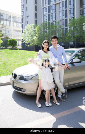 Felice famiglia giovane e auto Foto Stock