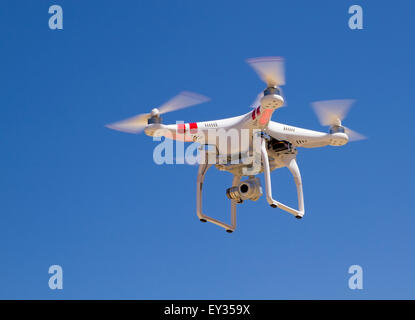 Quadrocopter in bilico con una telecamera contro un cielo blu Foto Stock