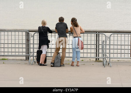 Tre persone appoggiata sulle ringhiere guardando attraverso Garrone Fiume Bordeaux in Francia Foto Stock