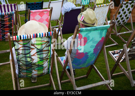 Posto a sedere in giardino floreale al Tatton Park, Cheshire, Regno Unito, 21 luglio 2015. Manchester School of Art, con la loro mostra, a motivi geometrici, telaio in legno pieghevole Classic Deck Chair Artschool; Summer Lawn sdraio a righe, al RHS Flower Show. Ogni sedia a sdraio è stata ridisegnata individualmente e ricreata da artisti e designer della Manchester School of Art Foto Stock