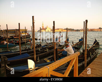 Gondolieri preparazione gondole Ormeggiato accanto a Piazza San Marco a sunrise. Venezia. L'Italia. Foto Stock