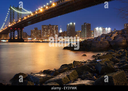 Vista notturna verso Manhattan da Brooklyn con la Manhattan Bridge spanning l'East River. Foto Stock