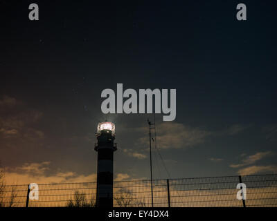 Faro di riga in una notte stellata con congelati del Mar Baltico Foto Stock